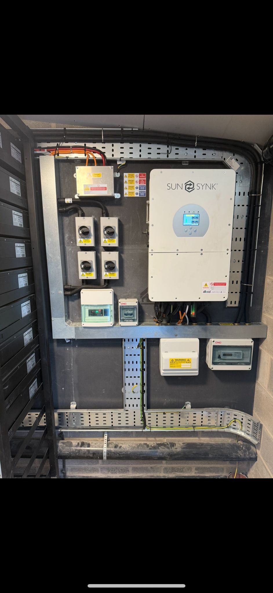 Solar technician working on battery and inverter equipment