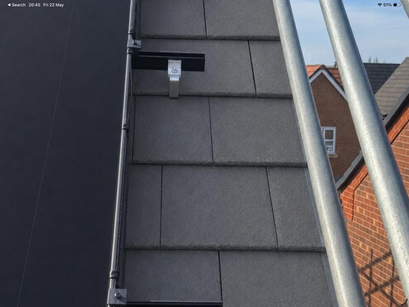 Close-up of solar panel mounting on roof tiles