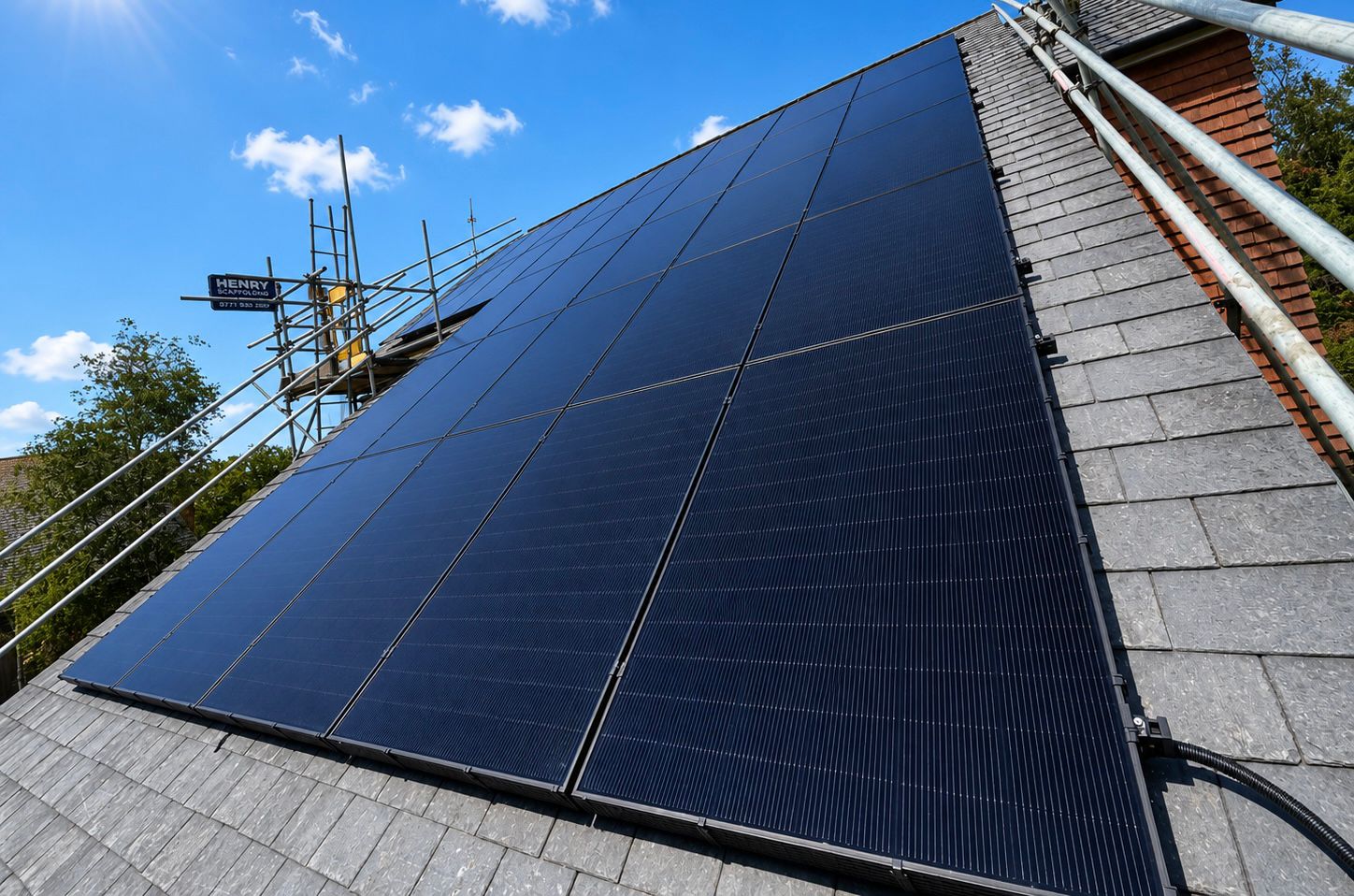 Large all-black solar panel array on a slate roof